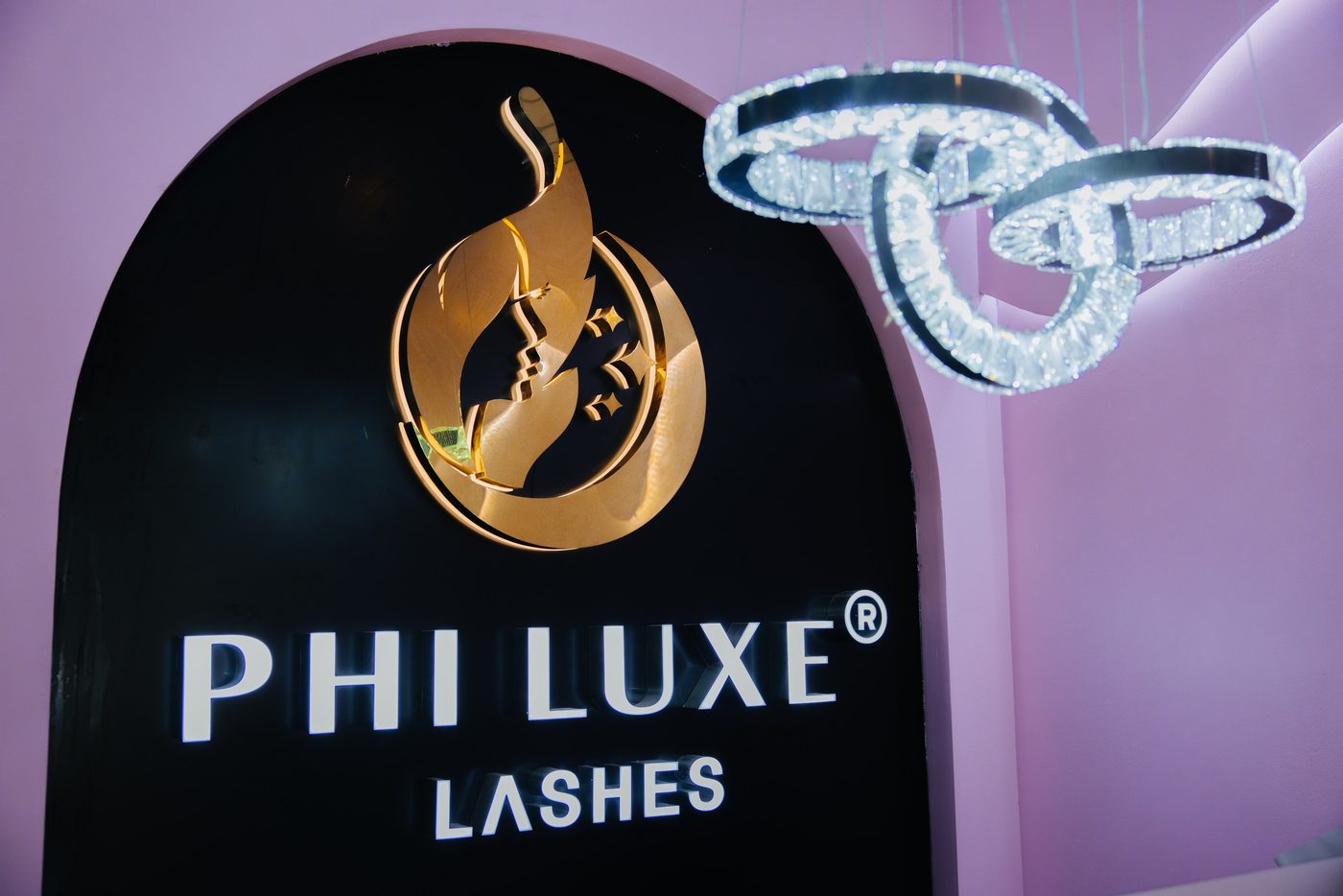Beleuchtete Logowand im Studio mit Kristallleuchter, PHI LUXE LASHES®